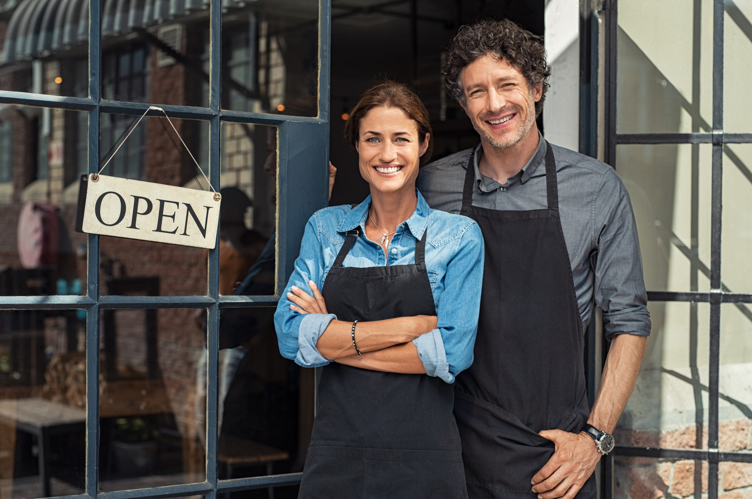 shop local two people standing in doorway by open sign
